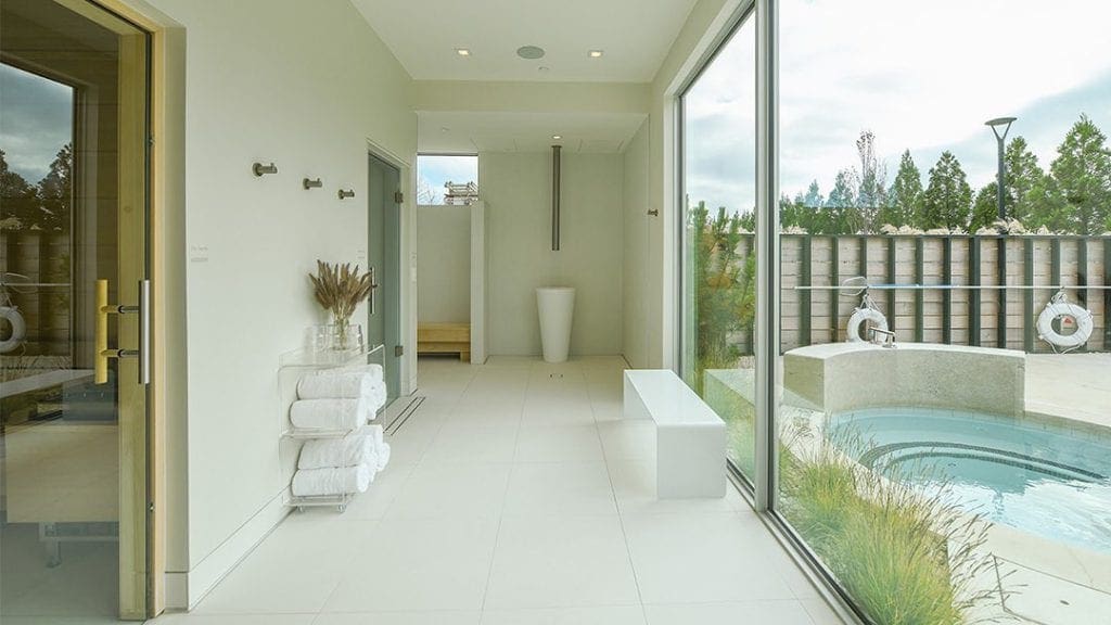 Inside the clean white spa at Shou Sugi Ban House, with a nearby soaking pool.