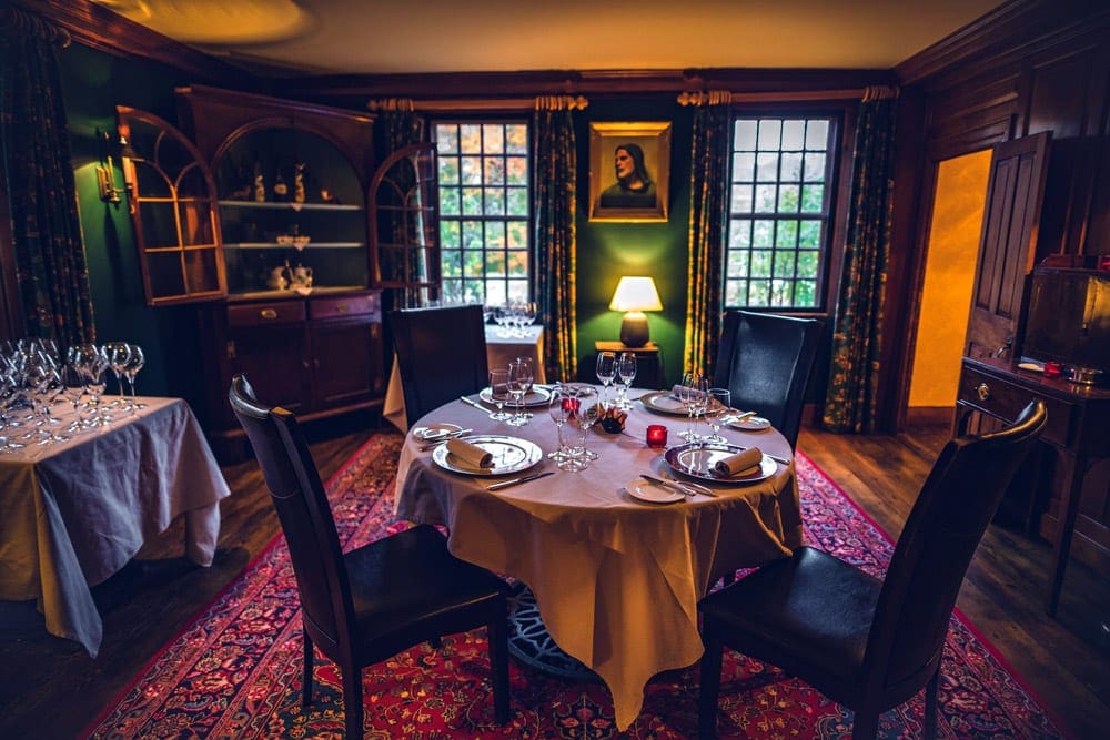 A charming dining area at Winvian Farm, featuing chic linens and mood lighting.