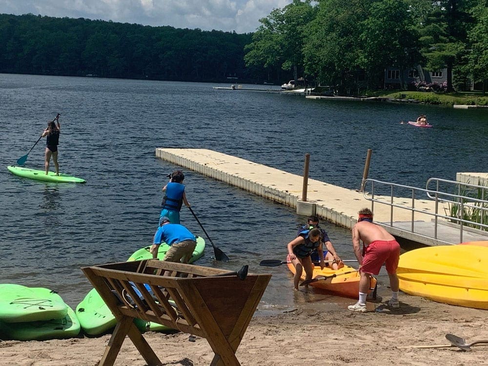 Kayakers enjoy the beach and water at the Woodloch Resort.