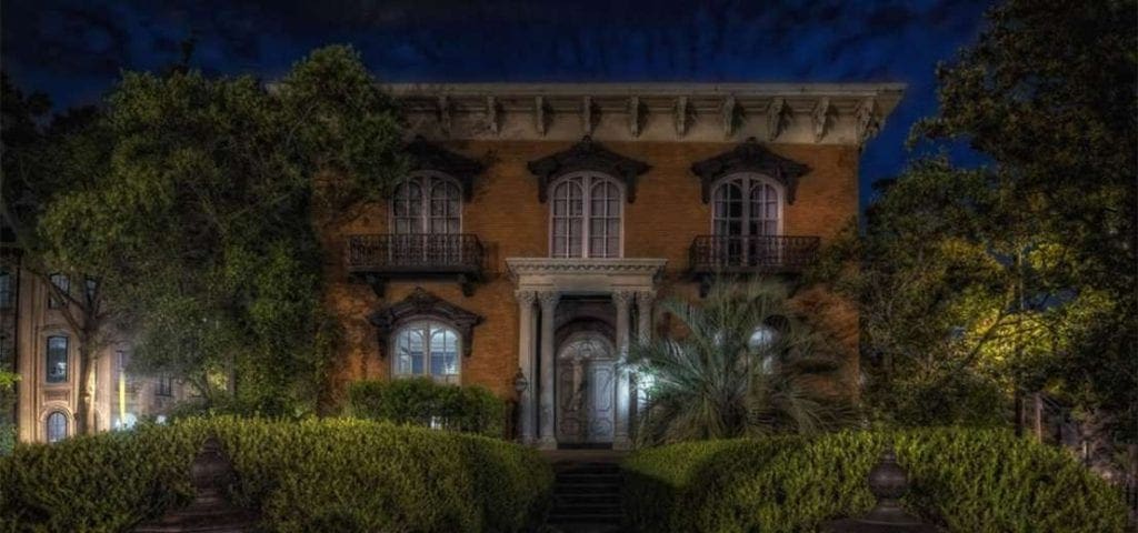 A view of a ghostly building at night in Savannah on the Grave Tales Ghost Tour. Savannah is one of the best places to stop on an NYC to Miami itinerary for families!