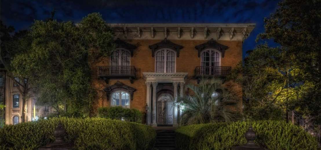 A view of a ghostly building at night in Savannah on the Grave Tales Ghost Tour, one of the best things to do on a Savannah itinerary with kids.