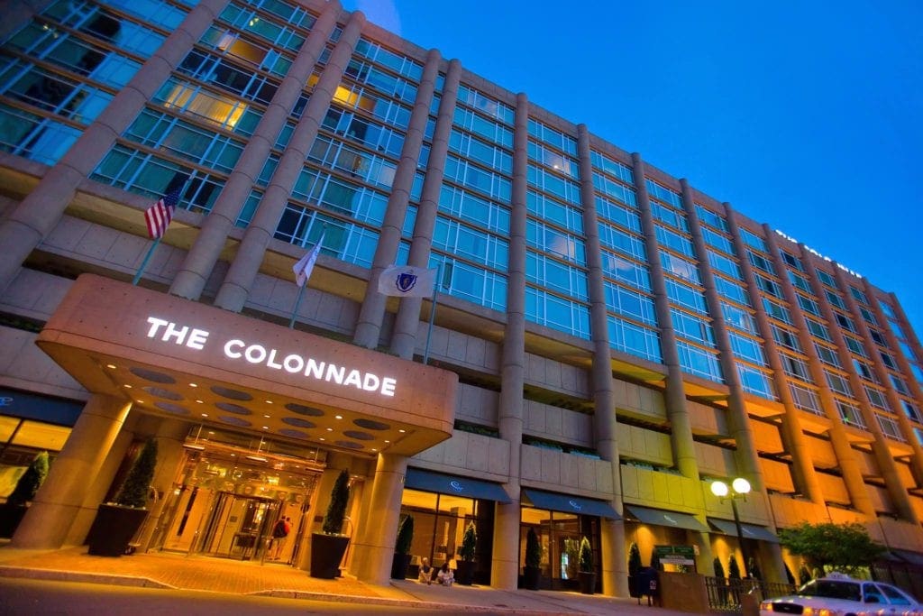 The brighly lit entrance to The Colonnade Hotel in the evening, one of the best hotels in boston for families