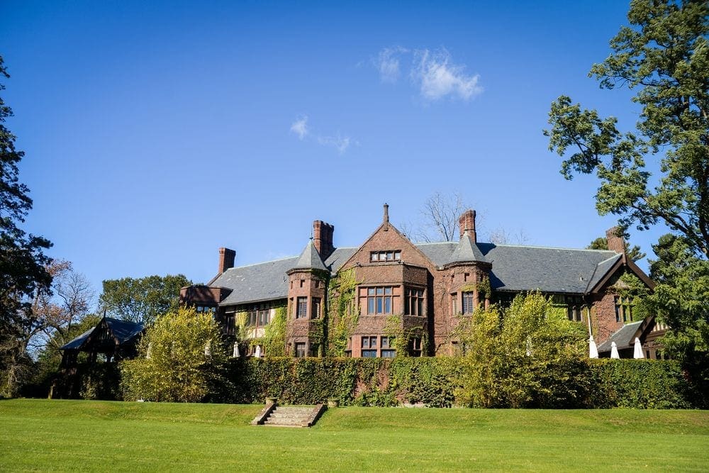 The grand entrance to the historic Blantyre, one of the best locations for a romantic getaway in the Northeast, covered in ivy and greenery.