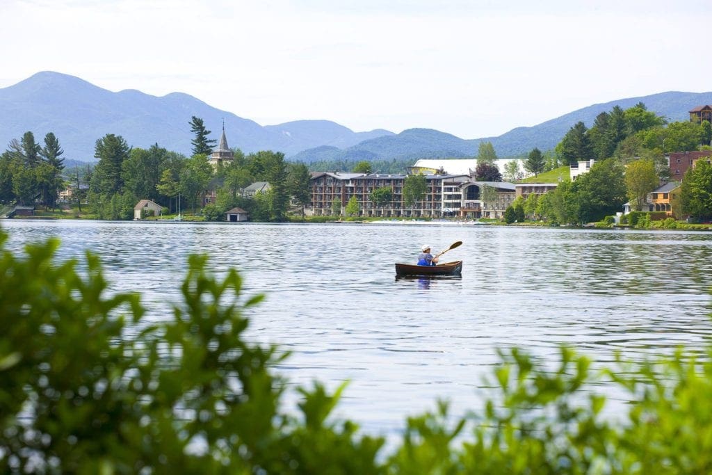 A man paddles around a lake off-shore from Golden Arrow Lakeside Resort, one of the best family resorts in New York State.