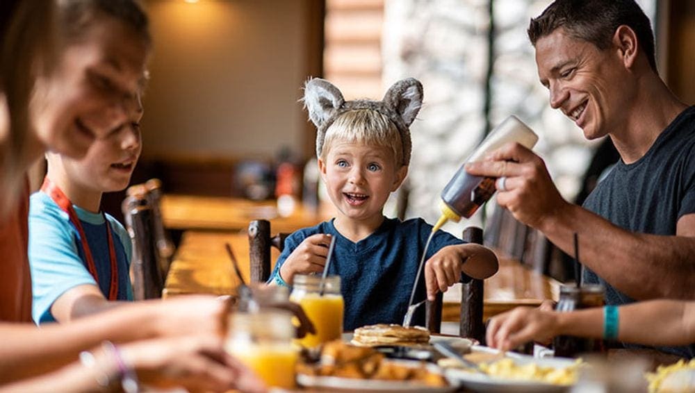 A family enjoys breakfast at the Great Wolf Lodge Water Park | Minnesota, knowing the best hotels to book is just one of the things on our list of travel resources for families.