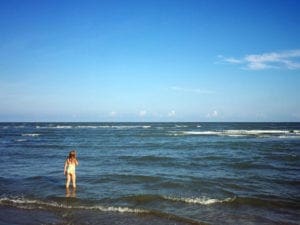 A young child plays in the water off the coast of Hilton Head while on a family vacation.