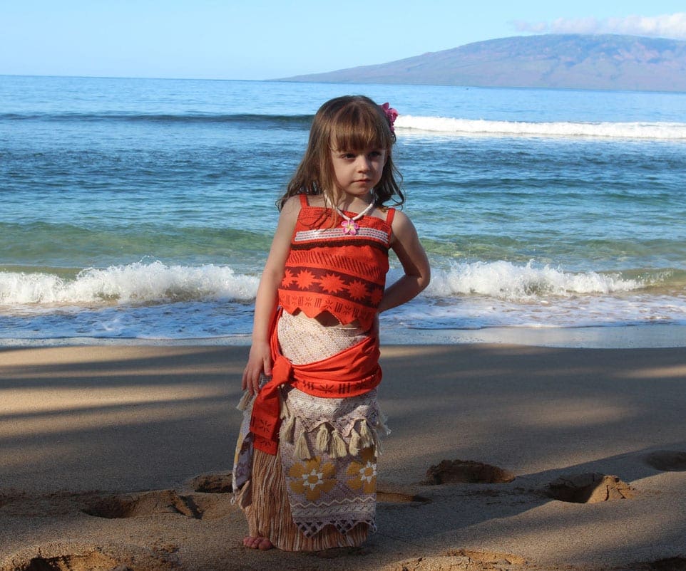 little girl on the beach in Maui wearing a read Hawaiin dress