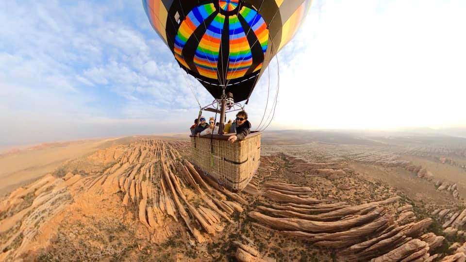Four people explore Utah by air in a colorful hot air balloon ride, one of the best things to do in Moab with kids.