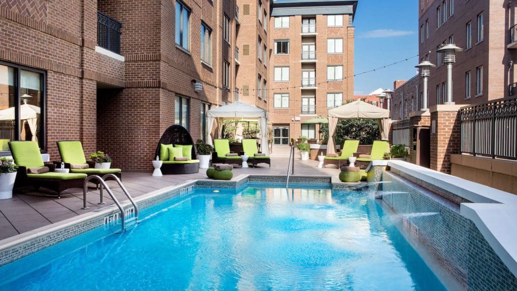 The outdoor pool, surrounded by lime green loungers at the Andaz Savannah – A Concept by Hyatt, one of the best hotels in Savannah for families.