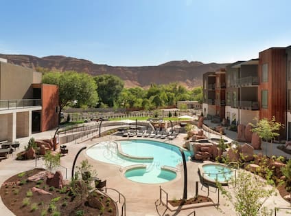 Left Image: The charming outdoor pool at the Hoodoo Moab, Curio Collection by Hilton. Right Image: The entance to the Hoodoo Moab, Curio Collection by Hilton at sunset.