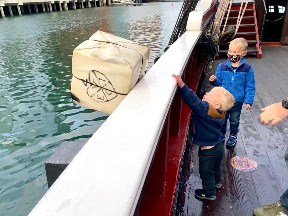 Two kids through a prop tea box over the ship at the Boston Tea Party Museum.