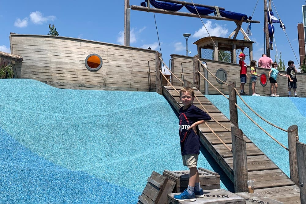 A young boy stands near a large place ship at the Boston Children’s Museum, one of the best things to do in Boston with kids.