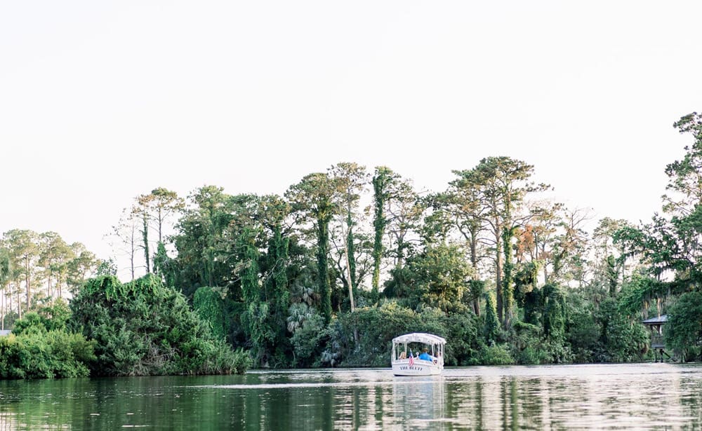 A small boat cruises down the river near the Montage Palmetto Bluff, one of the best hotels in Savannah for families.