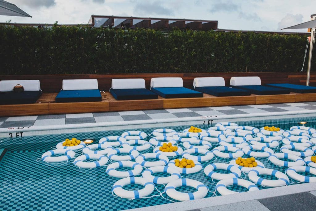 Several blue and white life savers float in the outdoor pool at the Perry Lane Hotel, a Luxury Collection Hotel, Savannah, one of the best hotels in Savannah for families.