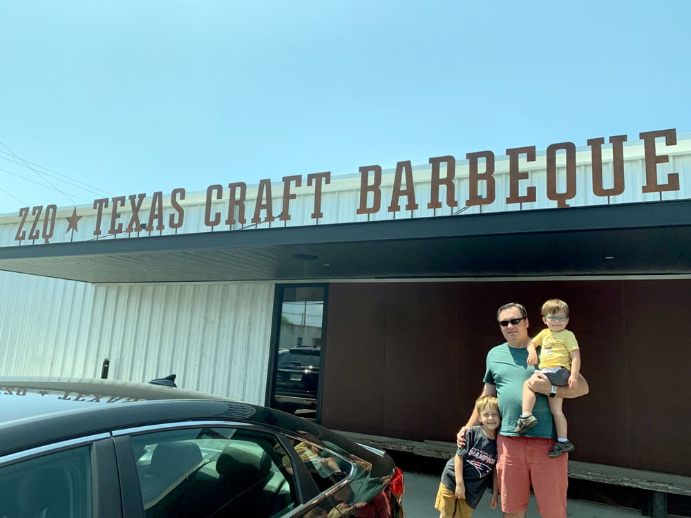 A dad and his two kids stand outside a Barbeque joint in Richmond, Virgina, one of the best weekend getaways near DC for families.