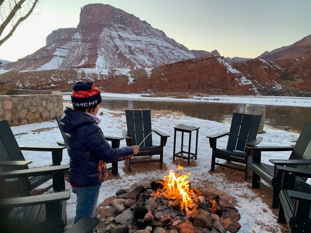 A young boy roasts a marshmallow over an open fire at Sorrel River Ranch Resort and Spa.