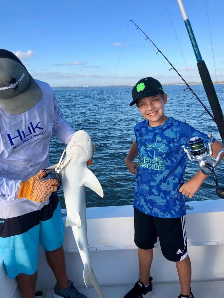 A young boy smiles while fishing on a charter boat off the coast of St. Simmons Island.