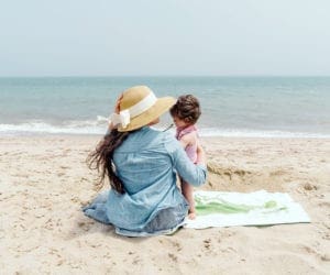 A mom holds her baby while enjoying a day at the beach in Nantucket.