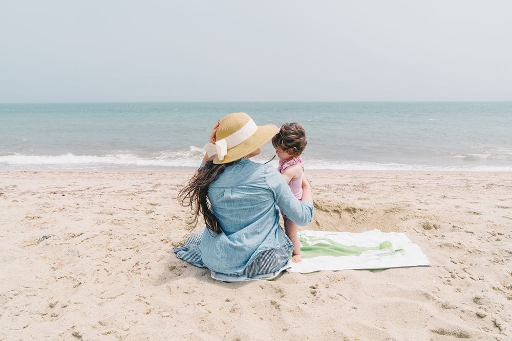 A mom holds her baby while enjoying a day at the beach in Nantucket.