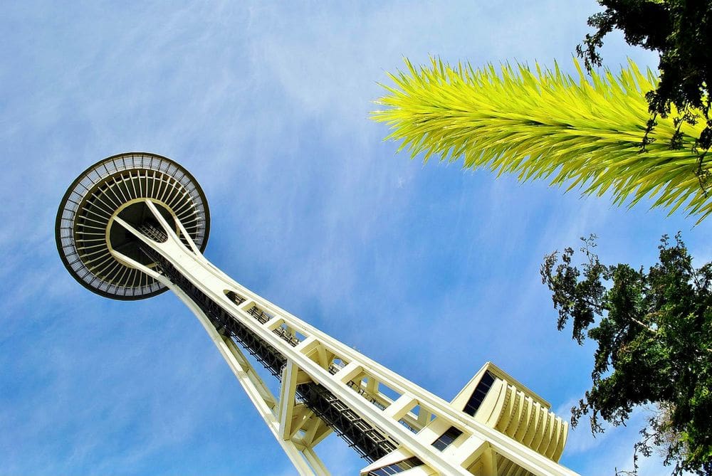 A view of lime green glasswork and nearby Space Needle at the Chihuly Garden & Glass Museum, a must stop on your 3-day Seattle itinerary for families.