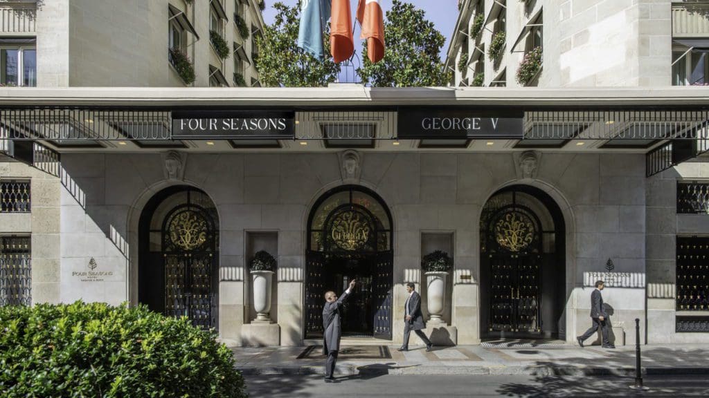 A hotel member flags a taxi outside the entrance of the Four Seasons Hotel George V, Paris, one of the best Paris hotels for families.