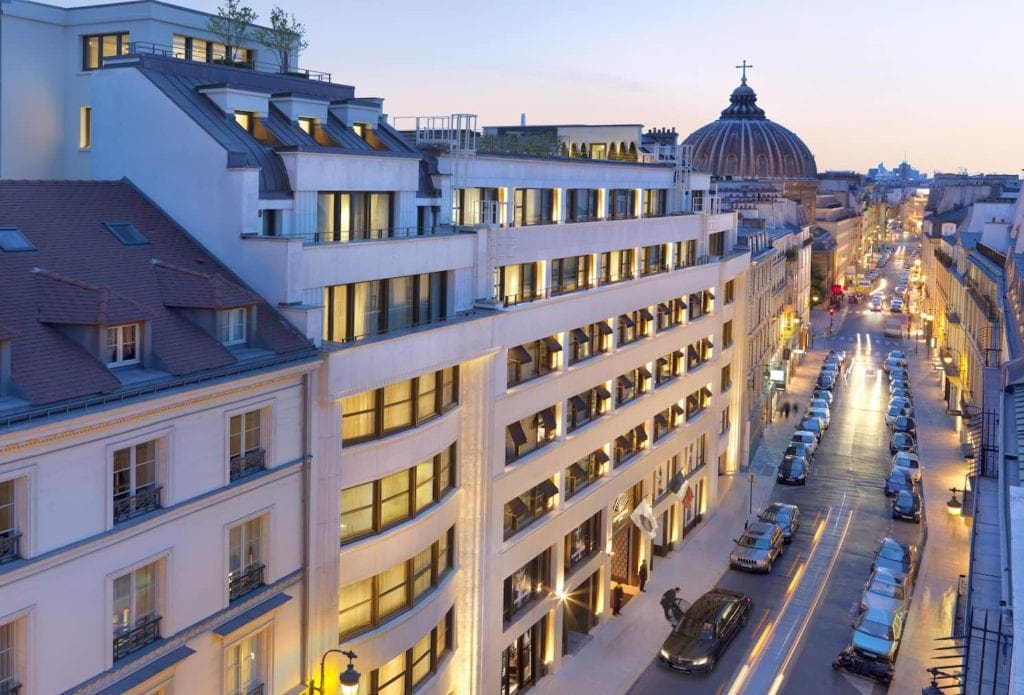 A street view in Paris at night with a view of Mandarin Oriental, Paris.