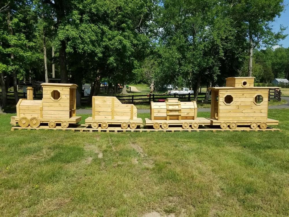 A large, stationary train made of wood at Montpelier Farms waits for kids to come play on it, a great location for fall activities near Washington DC for families.