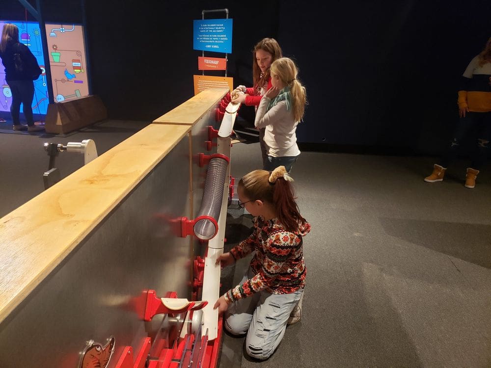 Three girls interact with an exhibit at the Putnam Museum in the Quad Citites, one of the best weekend getaways near Chicago for families