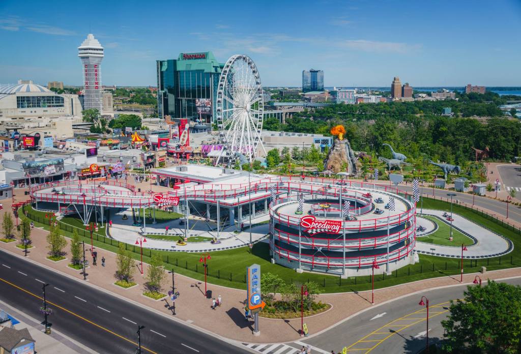 An aerial view of the brightly-colored Clifton Hill Amusements on a sunny day, featuring the large speedway.