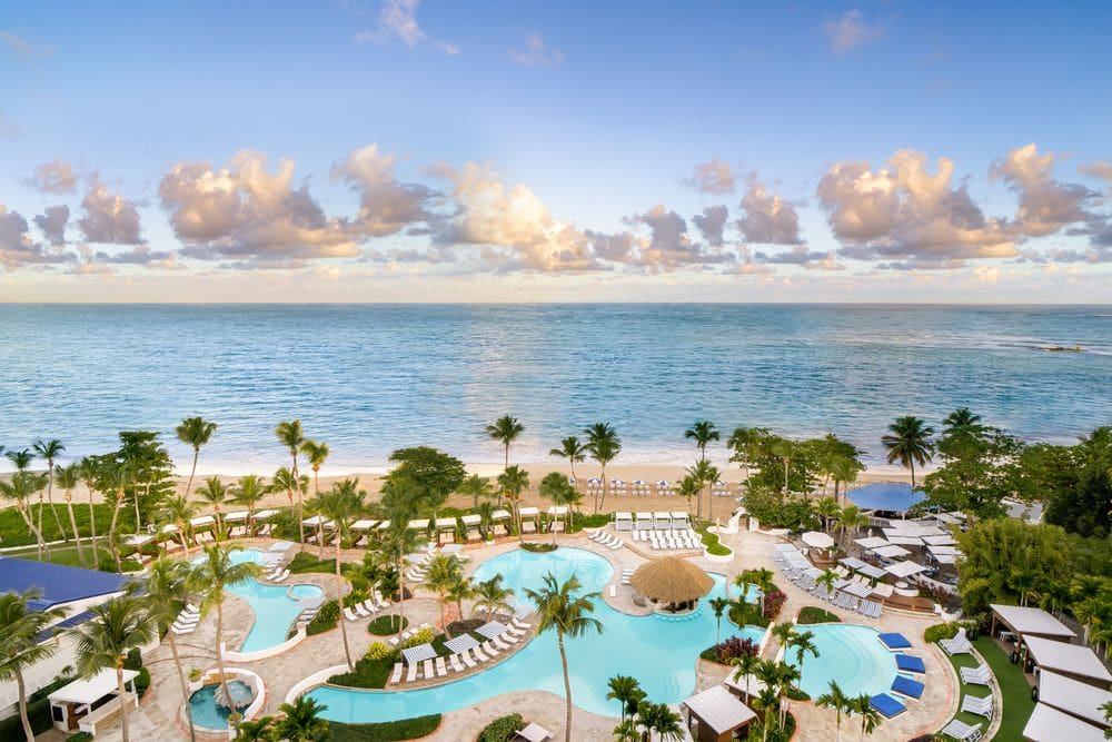 An aerial view of the pool and beach, extending into the ocean, at the Fairmont El San Juan Hotel.