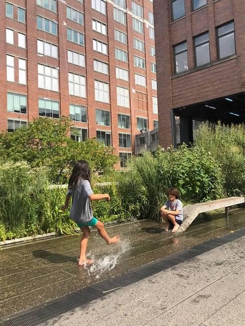 Two kids splash in the water on the High Line in NYC.