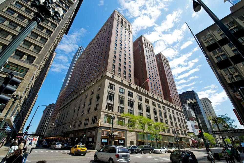 Outdoor view of the Palmer House, A Hilton Hotel, surrounded by yellow taxis and other cars in Chicago.