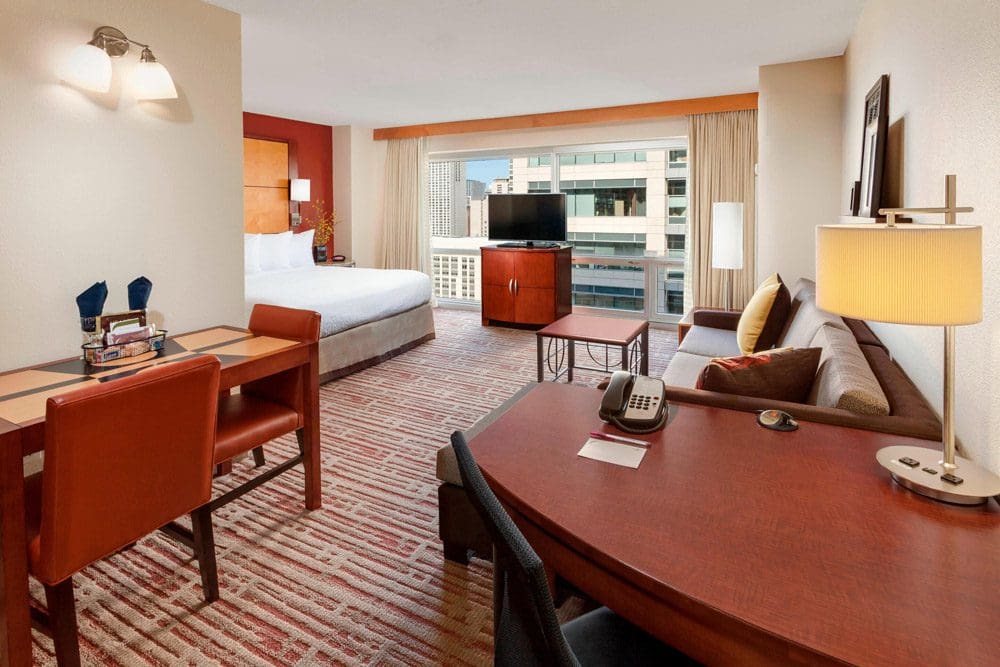 Inside a suite at the Residence Inn by Marriott Chicago Downtown / River North, featuring bright colors, a desk area, and other furniture.