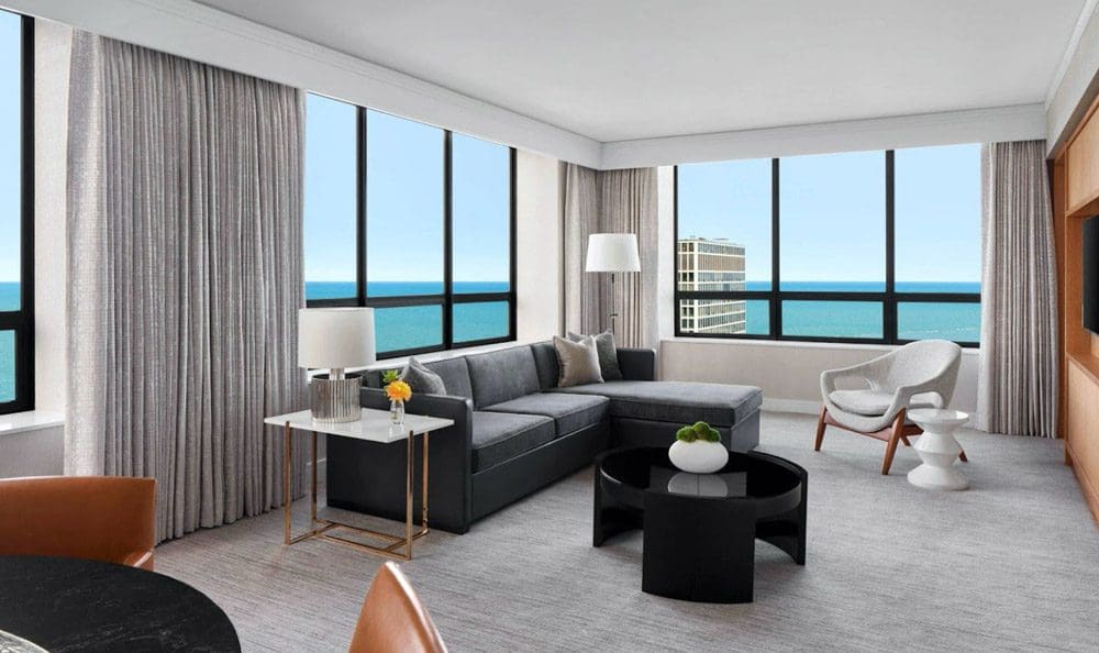 Inside one of the suites at the The Ritz-Carlton, Chicago, featuring a large sitting area and huge windows on two walls.