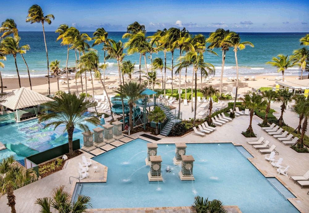 An aerial view of the pool area, large slide, and pool deck at the San Juan Marriott Resort & Stellaris Casino.