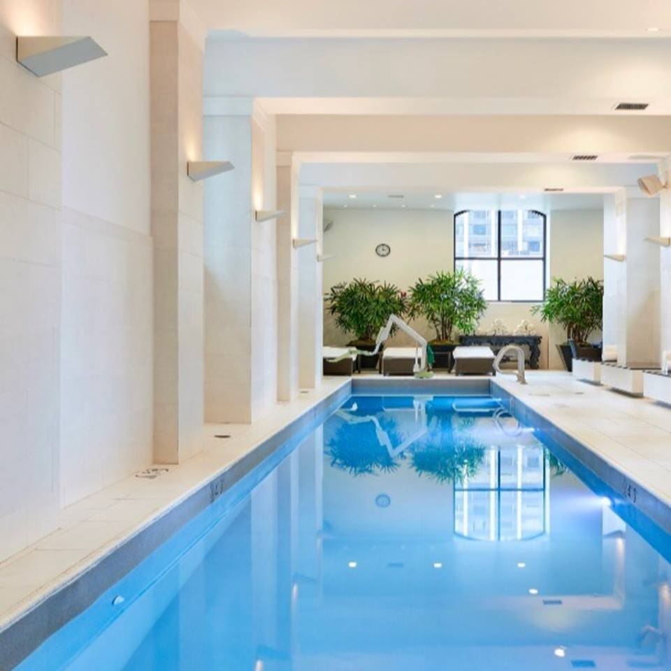 View of the long indoor pool at the Waldorf Astoria Chicago, one of the best family hotels in Chicago.