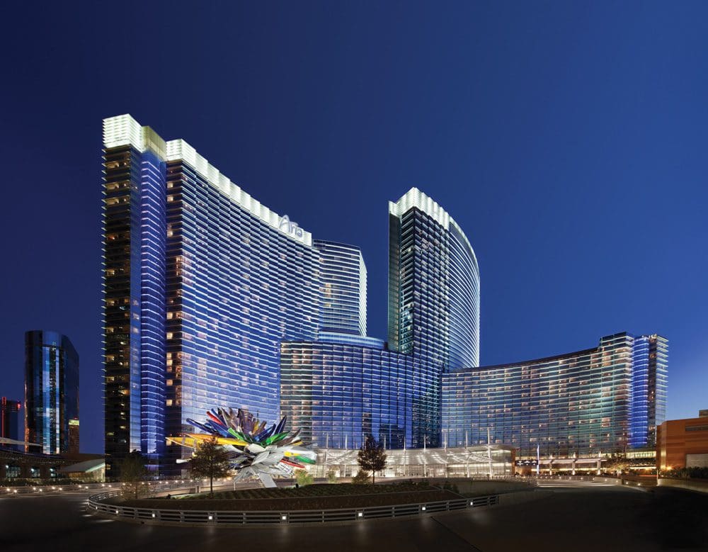 The shimmering exterior of the ARIA Resort and Casino at night.