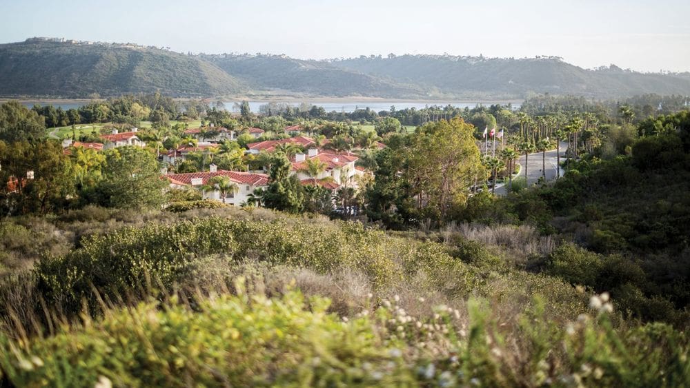 An aerial view of the Four Seasons Residence Club Aviara, North San Diego, featuring lush palms and Spanish-style red roofs.