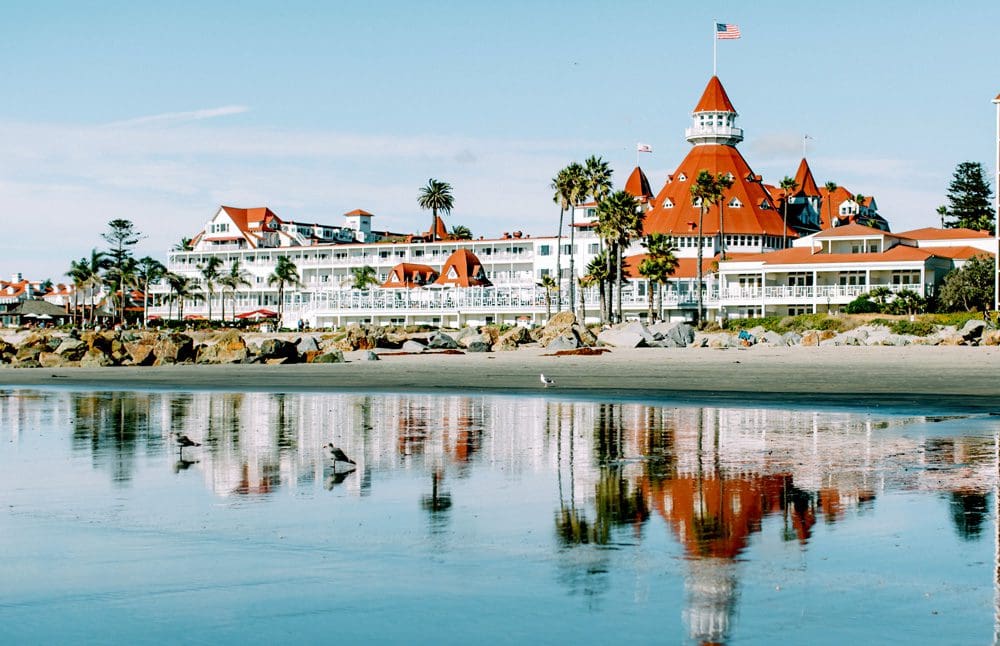 A view of the Hotel Del Coronado, Curio Collection By Hilton, one of the best San Diego beachfront hotels for families, across the water on a sunny day.