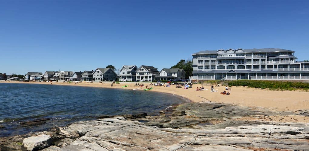 The beach at the Madison Beach Hotel, Curio Collection By Hilton, featuring a sandy shoreline and some large rocks.