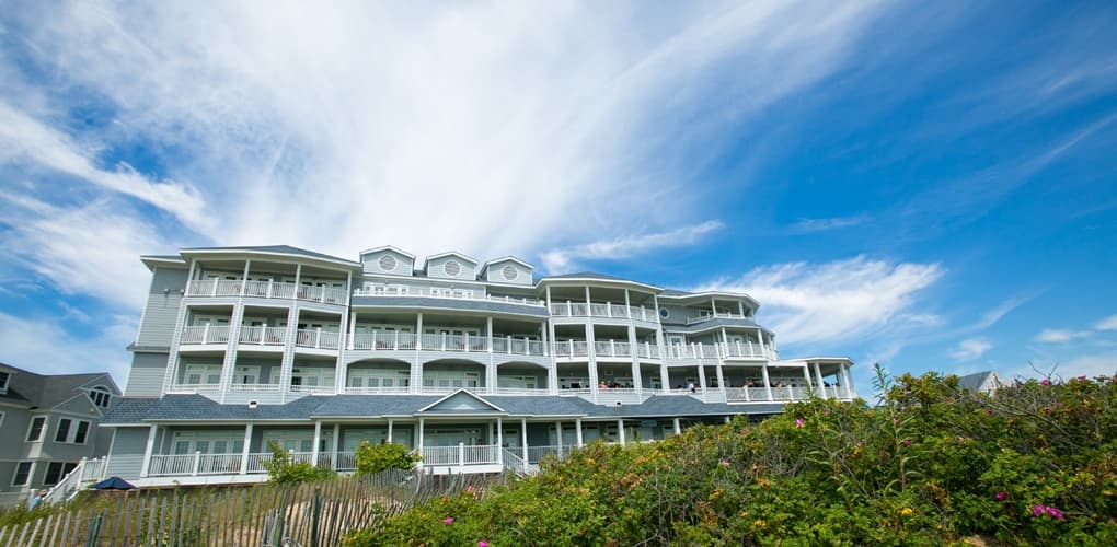 The exterior to the Madison Beach Hotel, Curio Collection By Hilton, on a sunny day.