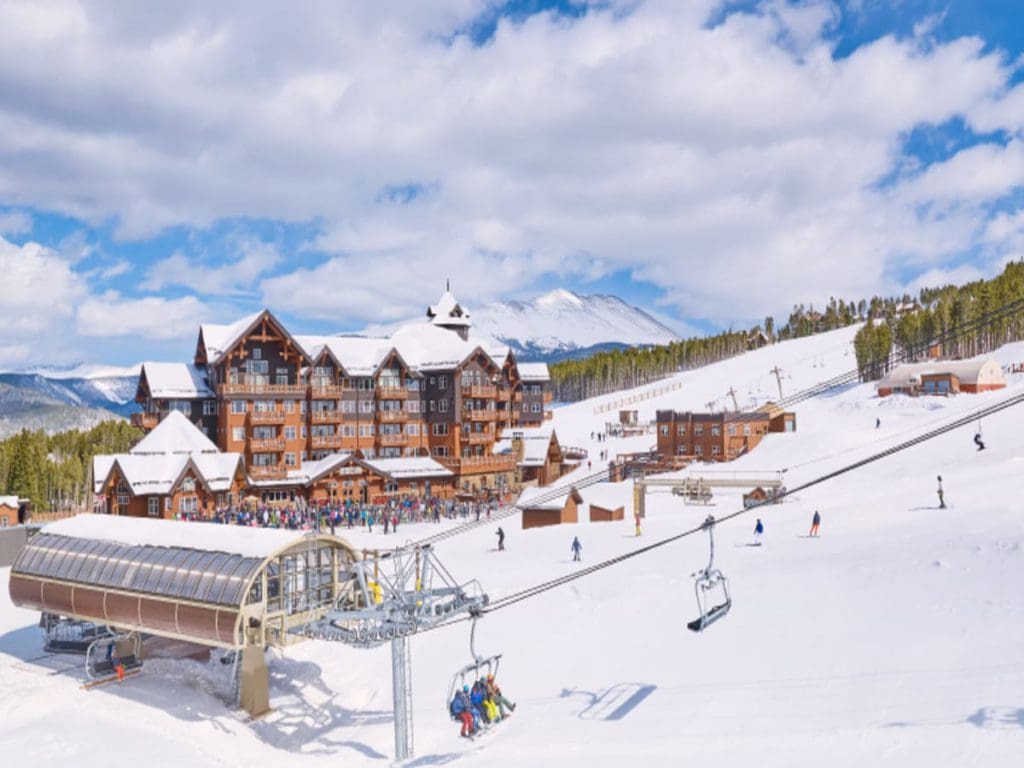 Families enjoy the on-site ski lift and well-maintained grounds at One Ski Hill Place, with resort buildings in the background, one of the best places to stay in Breckenridge during the winter with kids.