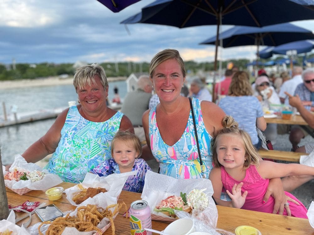 Three generations of woman, including two grandkids, sit together enjoying a meal at Sesuit Harbor Cafe in Cape Cod.