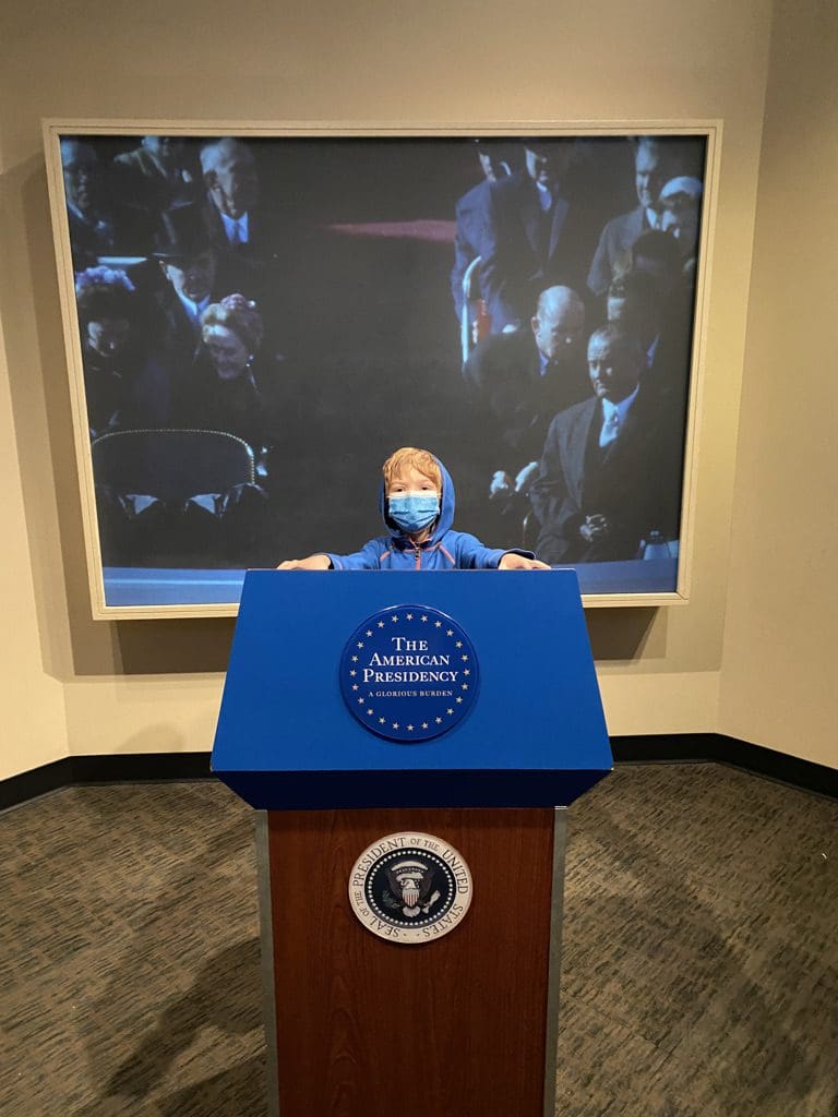 A young boy stands behind a podium at the Museum of American History in Washington, DC/.