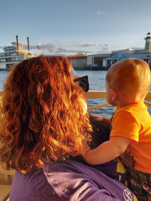 A mother holds her baby and looks out onto the river at Disney's Port Orleans - Riverside Resort.