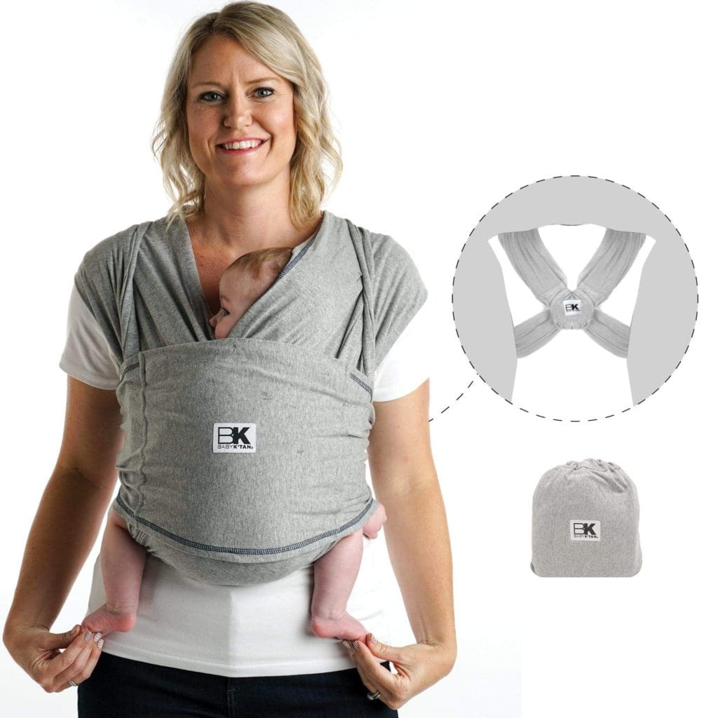 A mom holds her infant in a front carrier by Baby K'tan Baby Carrier, with a product aid on how the wrap works.