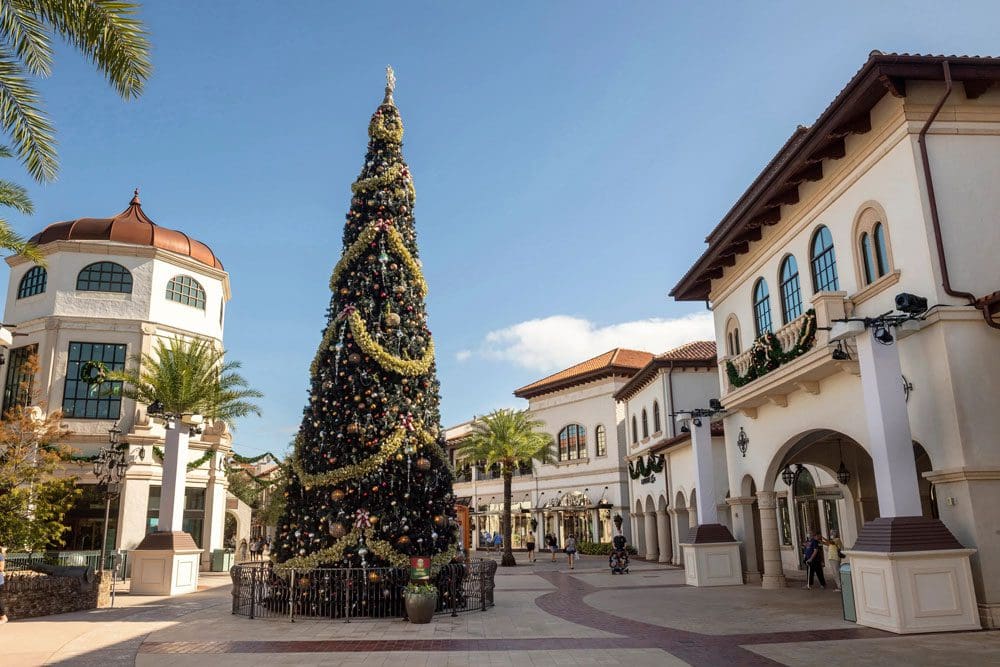 Disney Springs lit up, with a huge Christmas tree during the holidays, one of the best resorts for celebrating the holidays in Disney as a family.