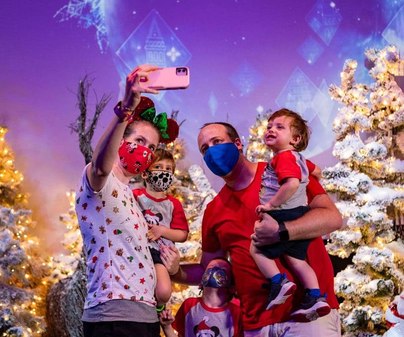 A family of five takes a selfie while celebrating the holidays at Epcot.