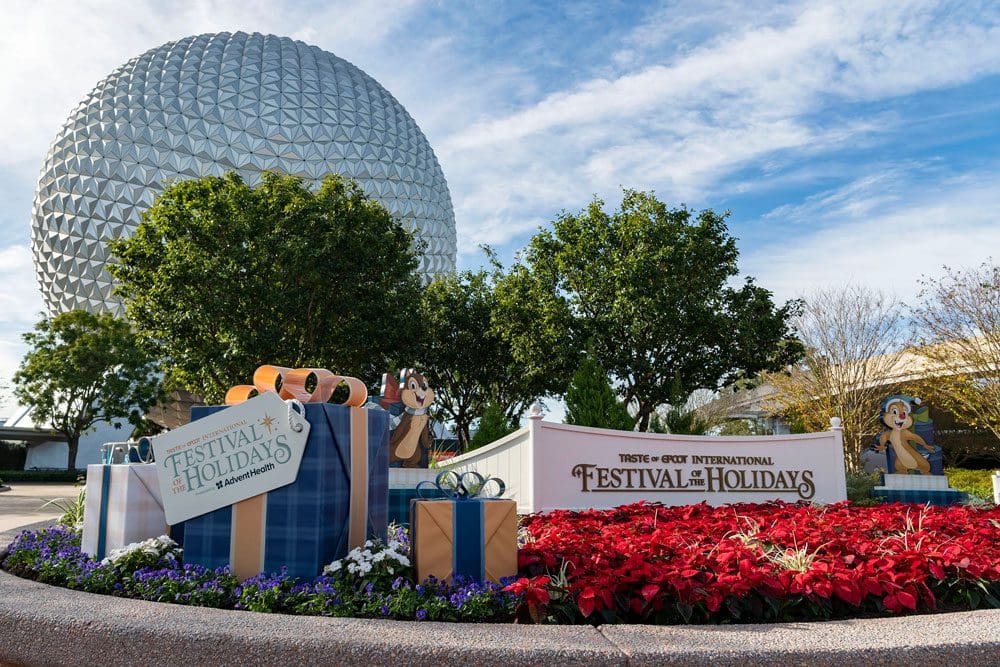 The entrance to Epcot decorated for the holidays, including a large gift display.