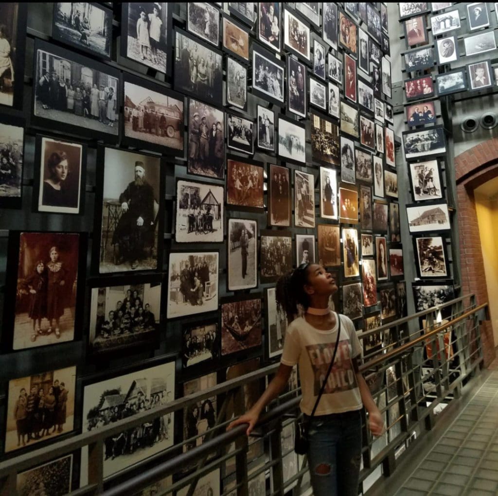 A young teen looks around a room full of photographs at the United States Holocaust Memorial Museum, one of the best DC museums for kids.